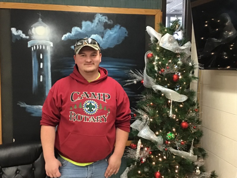 Photo of Sean Drexler standing next to Christmas Tree