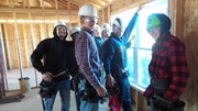 Construction Students helping to install a window from the interior.
